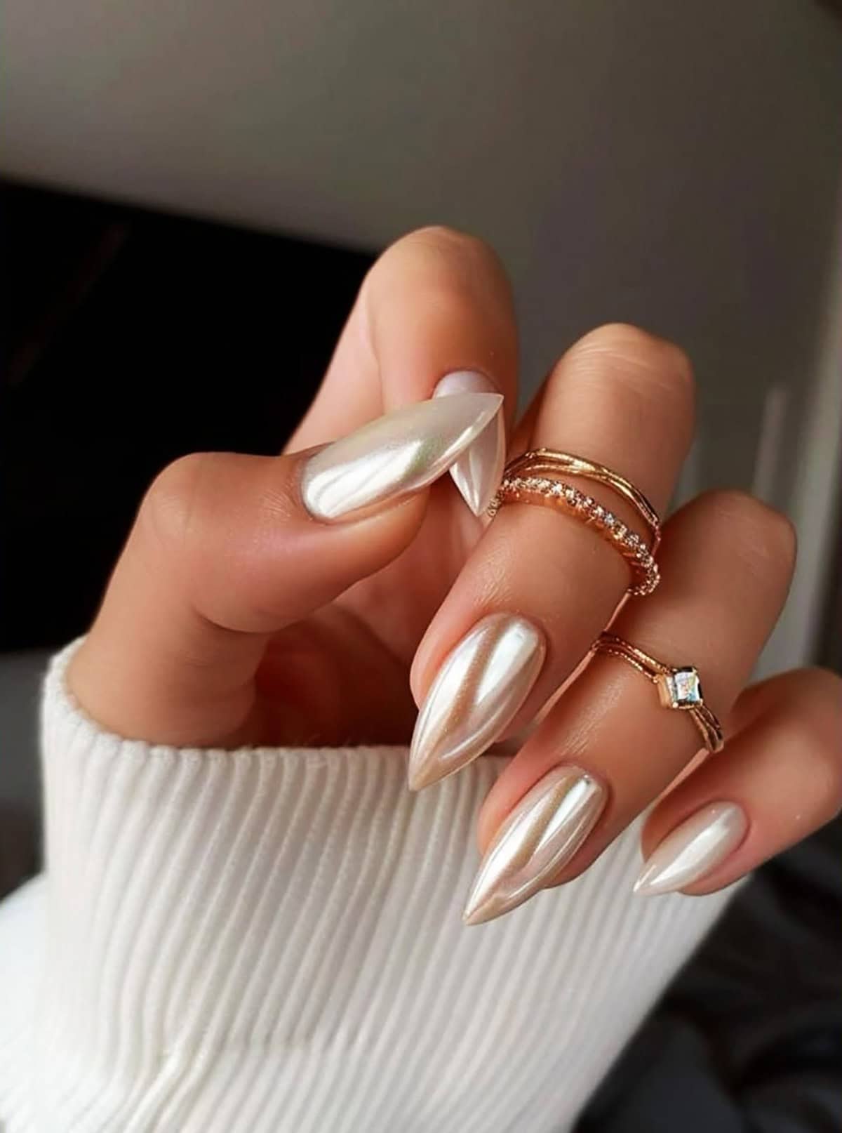 long stiletto nails with warm white pearly chrome finish and golden undertones white chrome nails